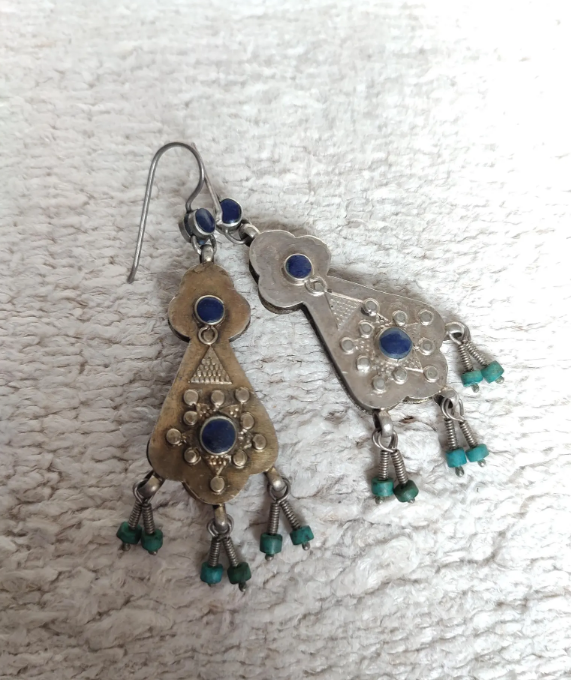 These special Kazakh style earrings are handmade out of silver, and are double faced; each side of the earrings is almost the same, one is gilded and the other side is plain silver. They carry Lapis Lazuli gems and smaller sized glass turquoise colored dangling beads.